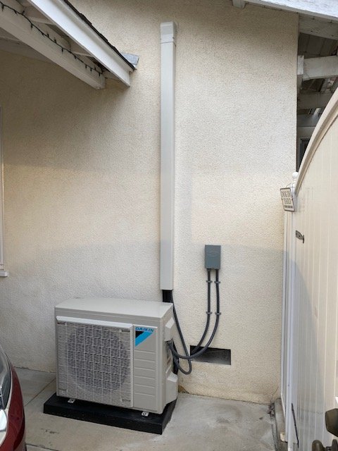 Daikin ductless mini-split outdoor unit mounted at a stucco home